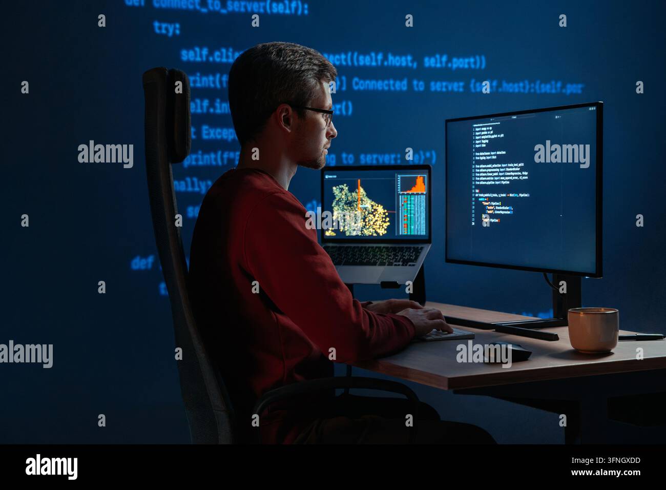 Data scientist che scrive codice per un progetto di intelligenza artificiale, con script di programmazione visibili su più monitor desktop. Programmista con occhiali che lavora davanti a più schermi di notte. Spazio di copia Foto Stock