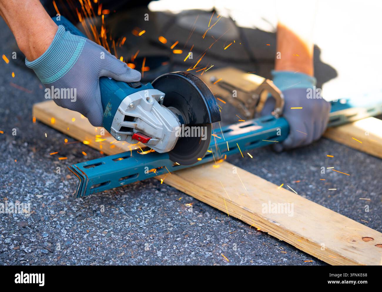 Operaio che taglia il metallo con molte scintille affilate utilizzando attrezzature per tagliare il ferro Foto Stock