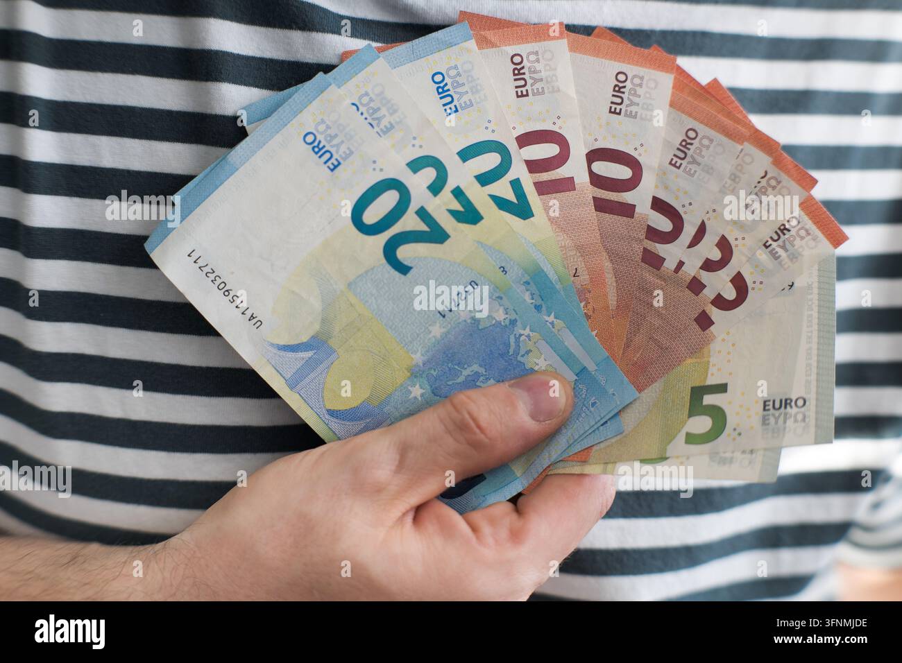 Un mazzo di euro nella mano di un uomo. Foto Stock