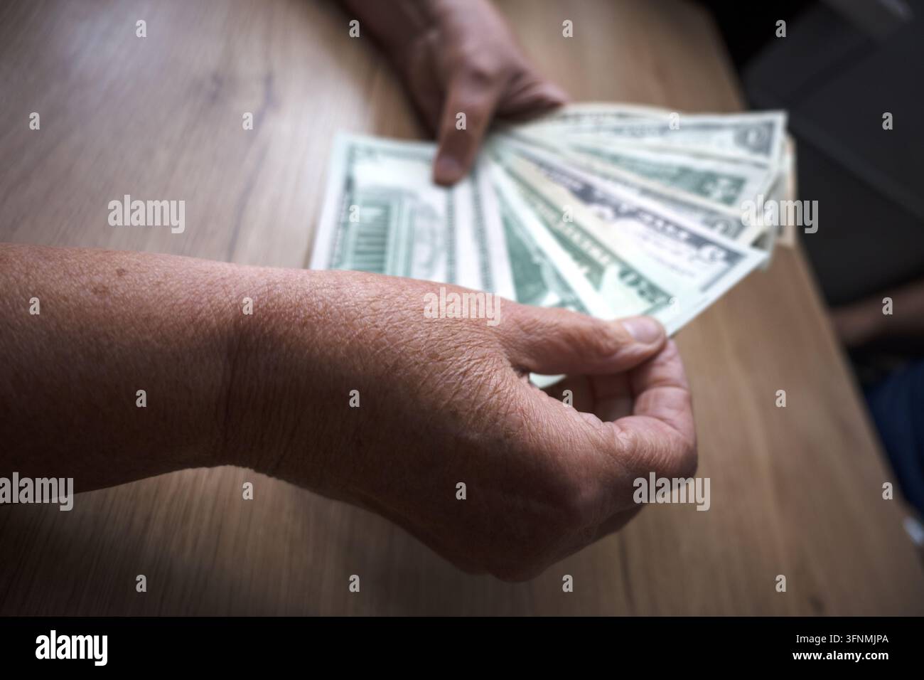 Un modesto budget familiare; dollari nelle mani di anziani. Foto Stock