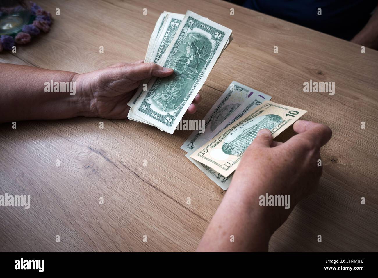 Un modesto budget familiare; dollari nelle mani di anziani. Foto Stock