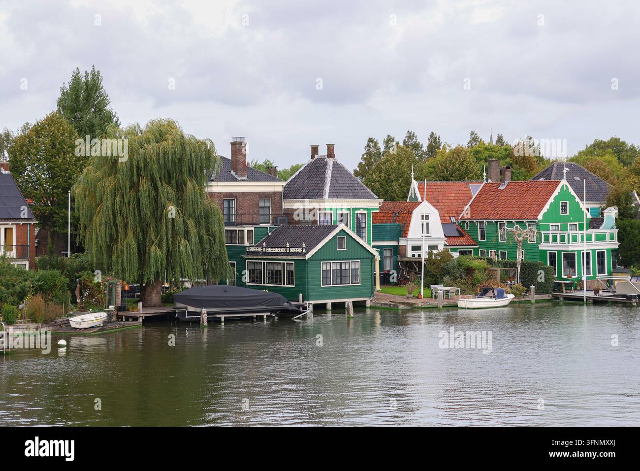 Zaanse Schans, Paesi Bassi - 1 ottobre 2026: Case storiche sul lungofiume olandese mostrano l'architettura zaana e il patrimonio locale. Foto Stock