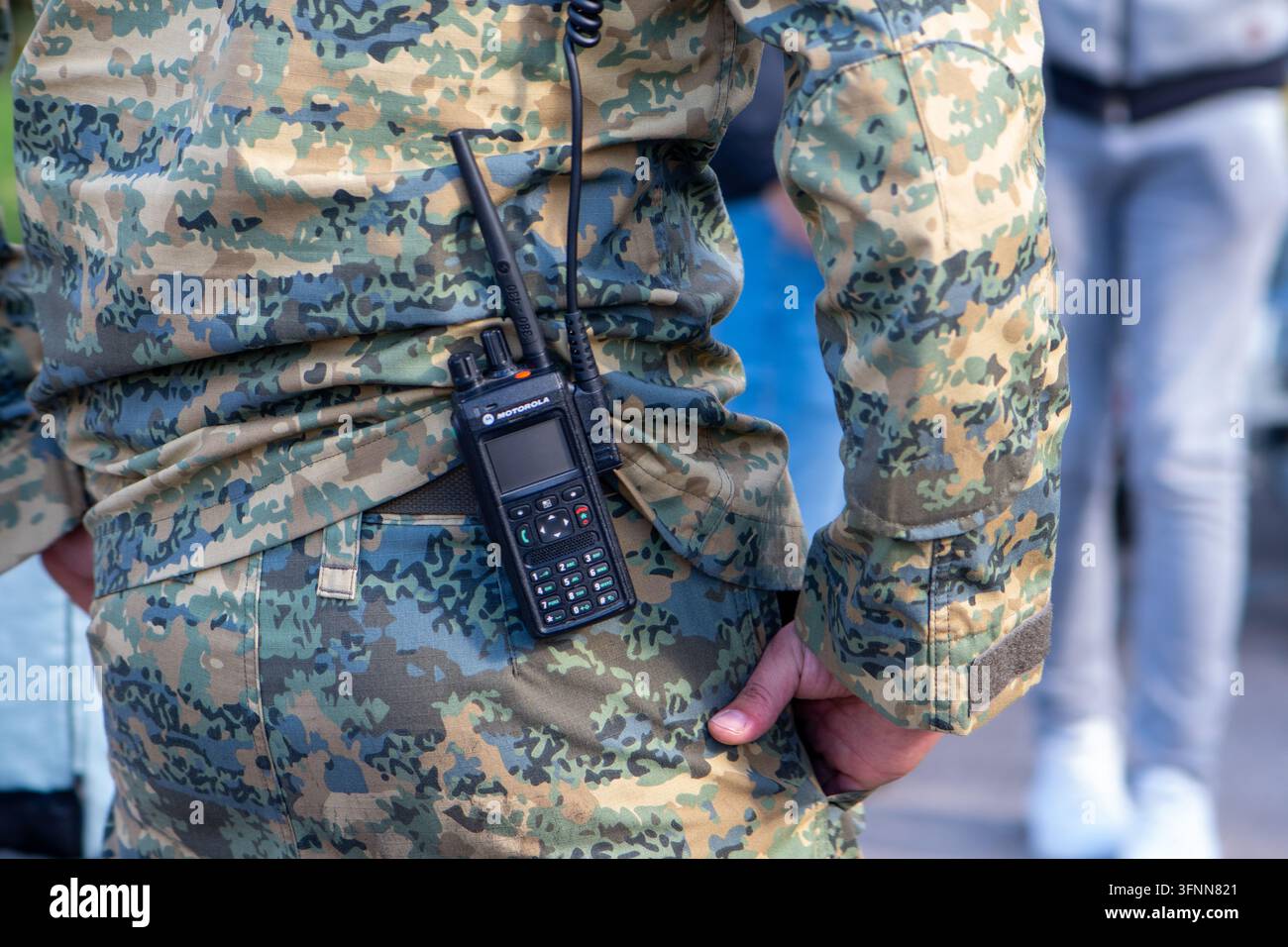 VIENNA, AUSTRIA, 26 ottobre 2025: Vista posteriore di un soldato mimetizzato che indossa una radio portatile in strada. Foto Stock