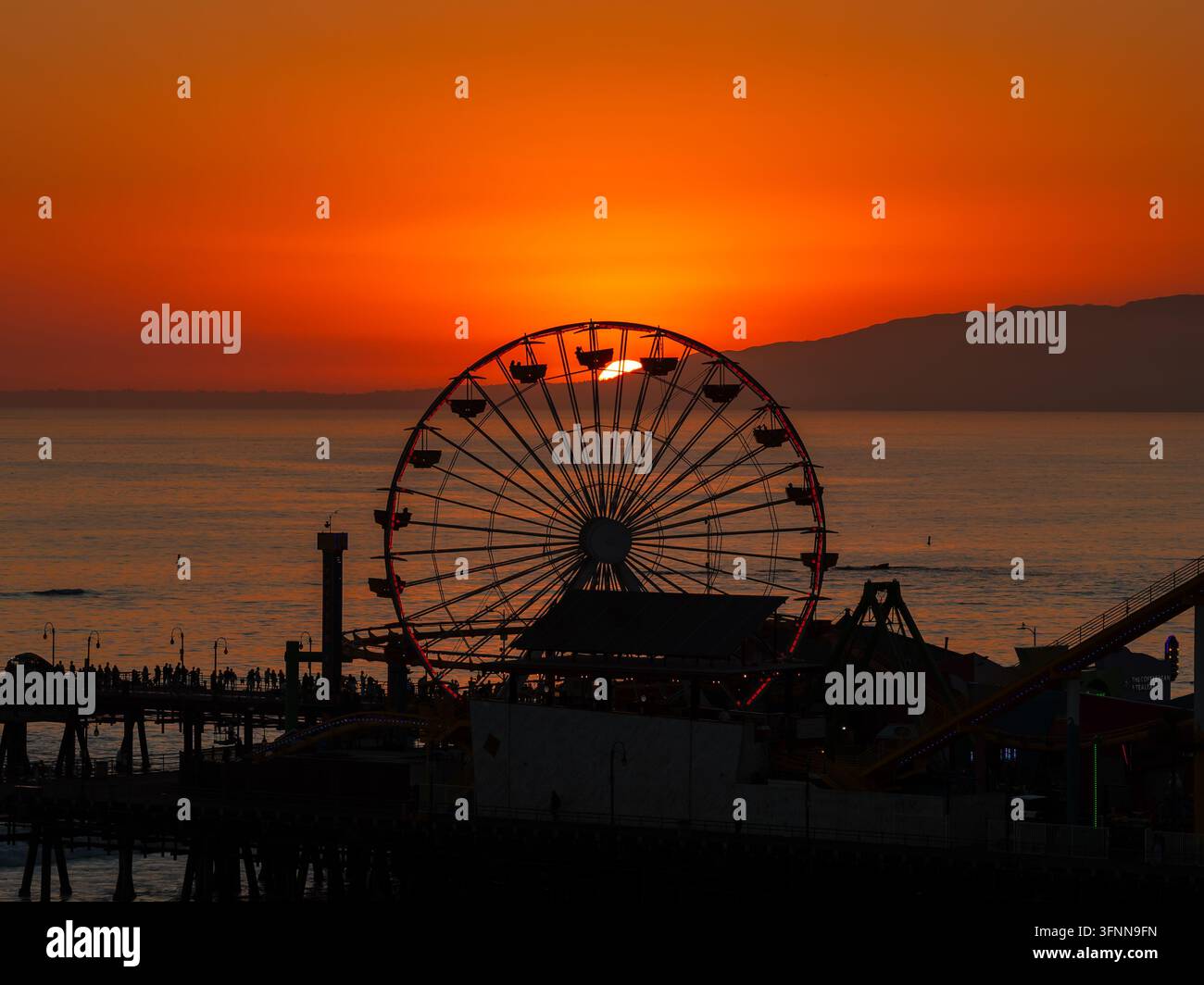Silhouette della ruota panoramica del molo di Santa Monica al tramonto Foto Stock