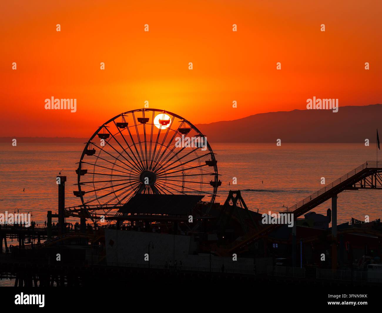 Silhouette della ruota panoramica del molo di Santa Monica al tramonto Foto Stock