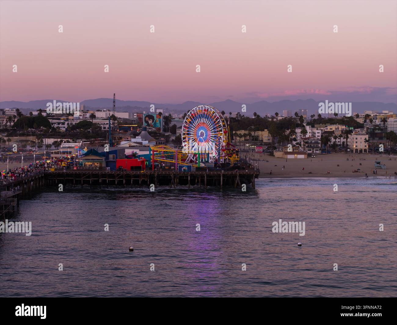 Giostra del pier di Santa Monica illuminata al crepuscolo Foto Stock