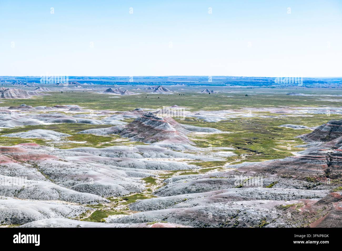 Prato verde e colline di bentonite nel parco nazionale delle Badlands Foto Stock