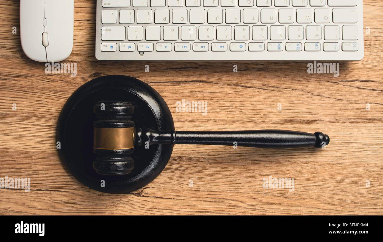 Martello di legno del giudice sulla scrivania con tastiera del computer e mouse che rappresentano il diritto online, i servizi legali su internet, il diritto informatico, la proprietà intellettuale e la giustizia Foto Stock