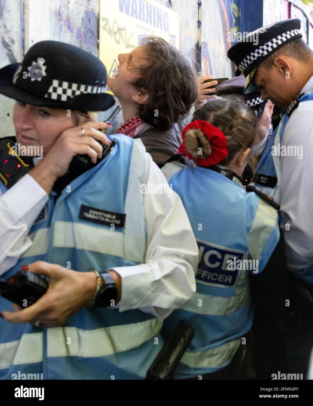 Londra, Inghilterra, Regno Unito. 4 ott., 2026. La polizia arresta un manifestante in Whitechapel Road, con una folla di manifestanti che grida per il suo rilascio durante la marcia della Battaglia di Cable Street. Credit: Ian Humphreys/Alamy Live News Foto Stock