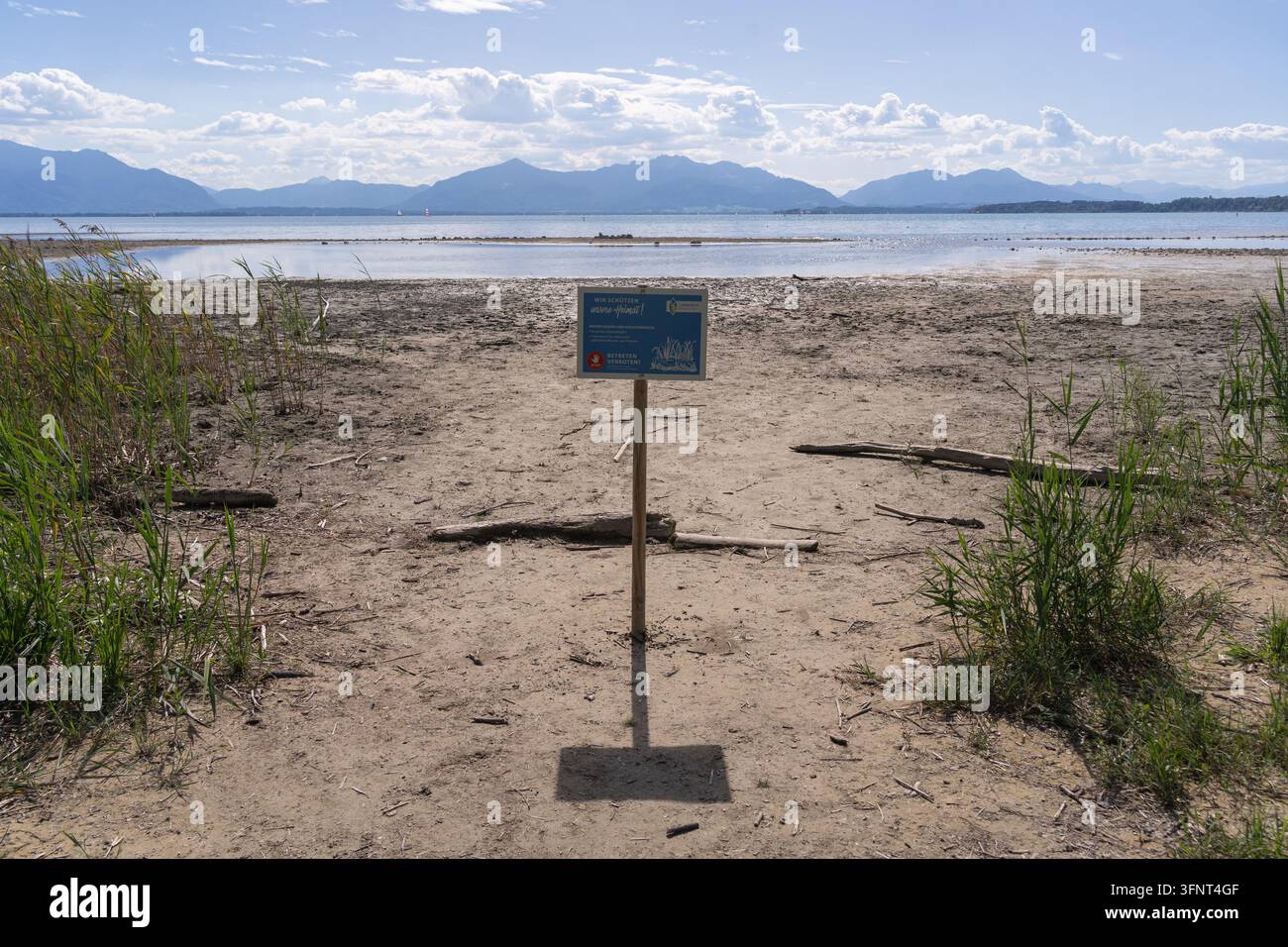 Segnale di conservazione della natura che indica un'area protetta di palude e riva al lago Chiemsee in Baviera, Germania, con una riva esposta e un basso livello dell'acqua Foto Stock
