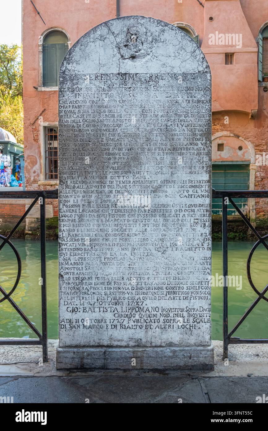La famosa pietra con iscrizione Stele del Pane lungo un canale a Venezia, Italia, raffigurante un antico decreto pubblico della Repubblica di Venezia Foto Stock