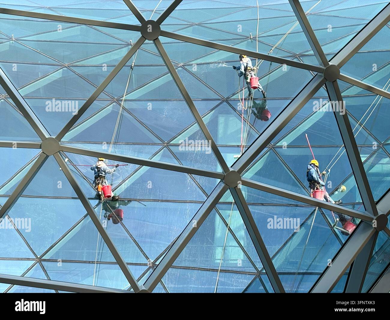 Uomini che puliscono l'esterno di The Orchard, Hamad International Airport, Doha, Qatar Foto Stock