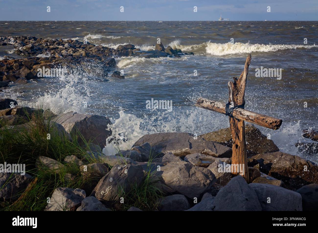 Una croce di legno alla deriva si erge tra le onde infrante mentre l'uragano Helene si avvicina alla costa del Golfo, il 26 settembre 2024, a Dauphin Island, Alabama. Foto Stock