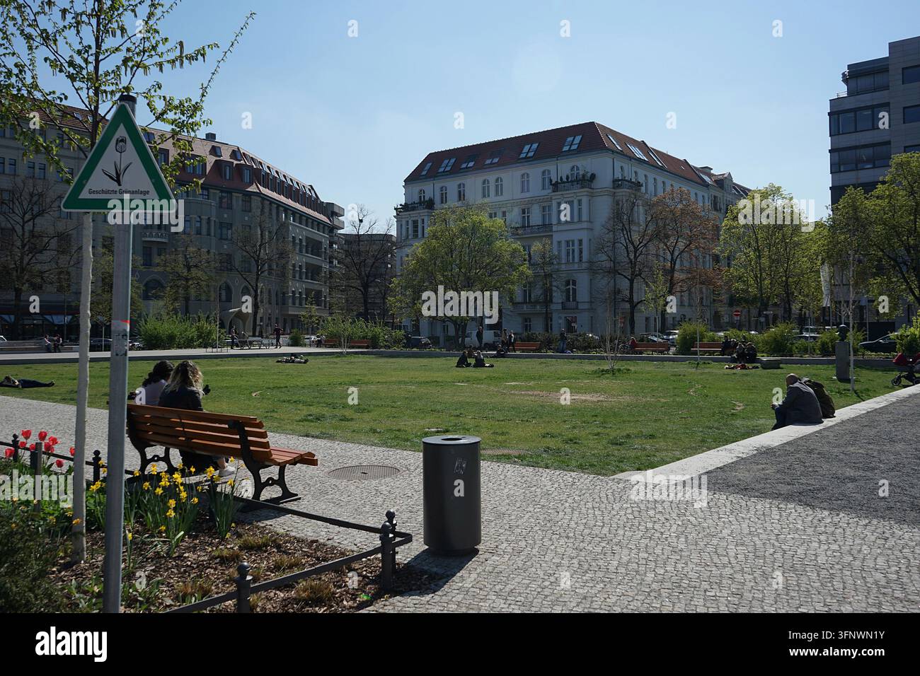Piazza pubblica Steinplatz con prato, alberi ed edifici per uffici in una giornata di primavera soleggiata, Berlino, Germania, aprile 2019 Foto Stock
