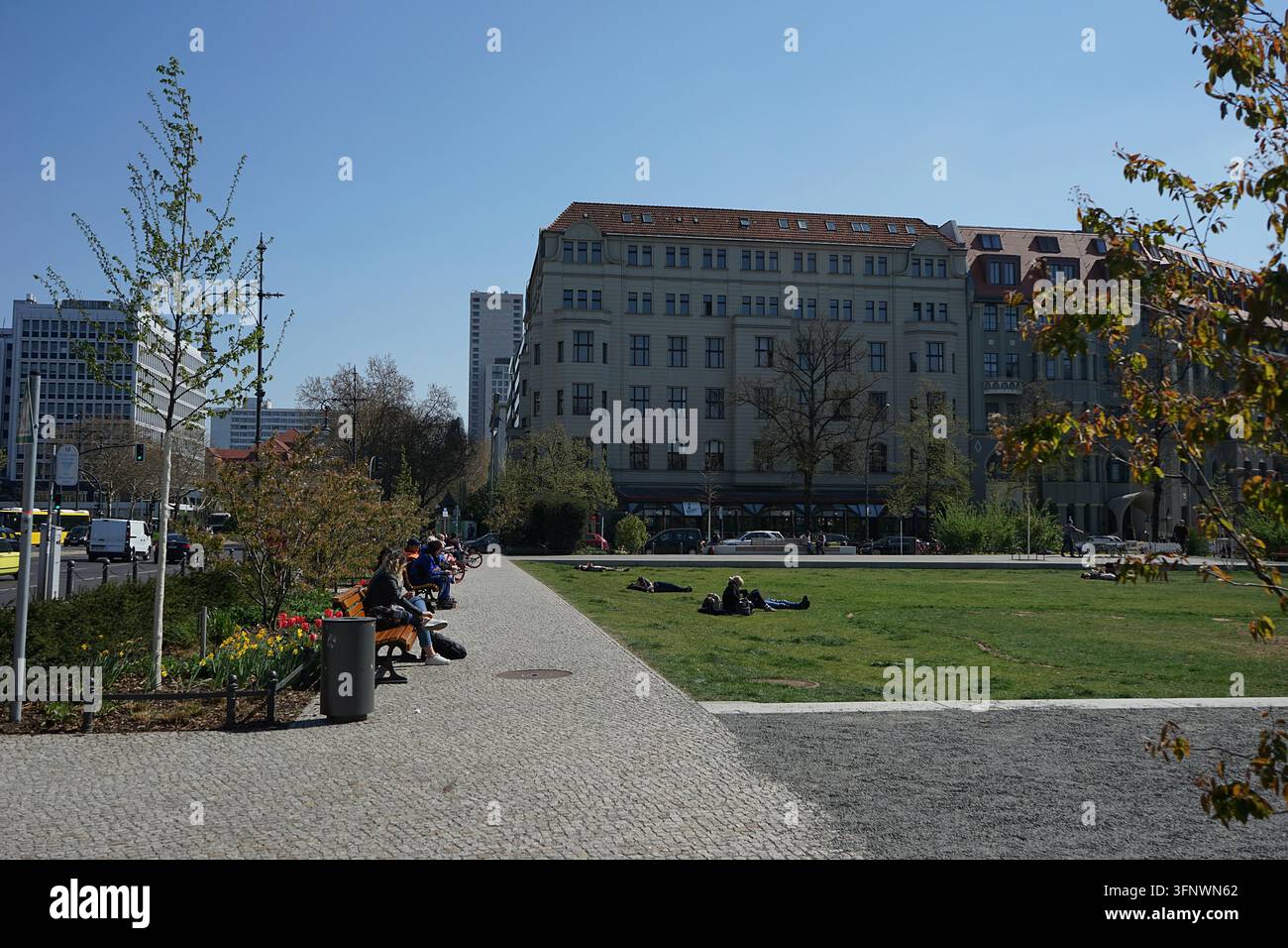 Piazza pubblica Steinplatz con prato, alberi ed edifici per uffici in una giornata di primavera soleggiata, Berlino, Germania, aprile 2019 Foto Stock