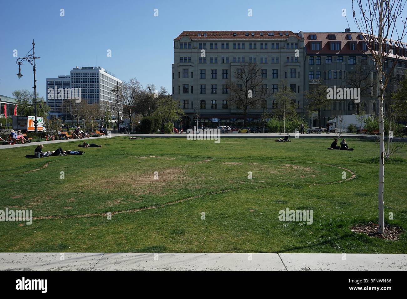 Piazza pubblica Steinplatz con prato, alberi ed edifici per uffici in una giornata di primavera soleggiata, Berlino, Germania, aprile 2019 Foto Stock