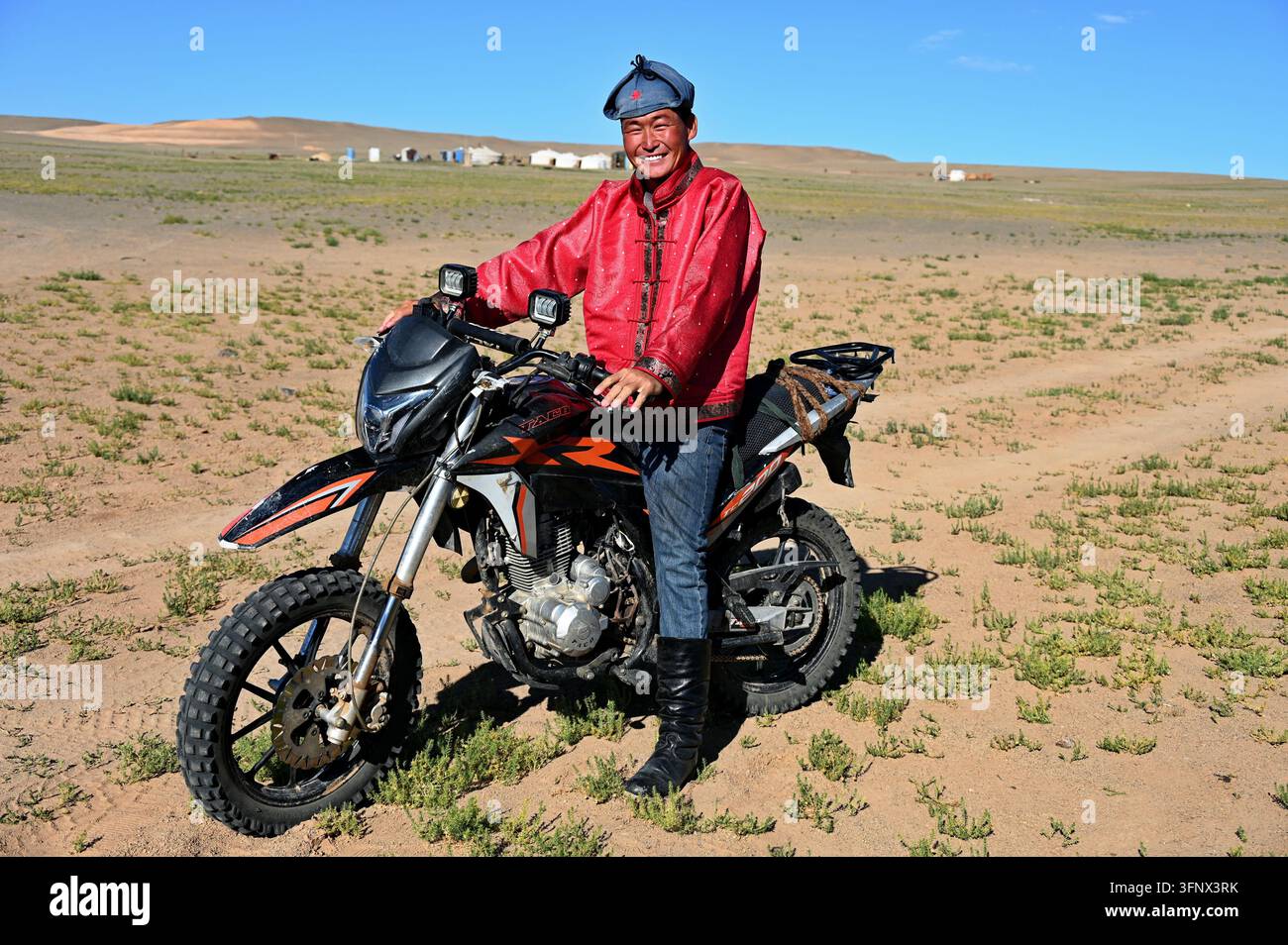 Dalanzadgad, Mongolia – 22 luglio 2026: Ritratto di un giovane mongolo in moto nel deserto del Gobi Foto Stock