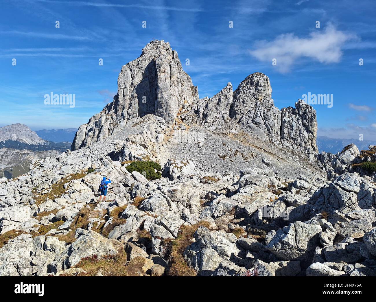 Imponente parete rocciosa con vista scenografica sulla cima montuosa TAC Spitze, Alpi di Hochschwab, Stiria, Austria. Scogliere rocciose ripide con uomo. Foto Stock
