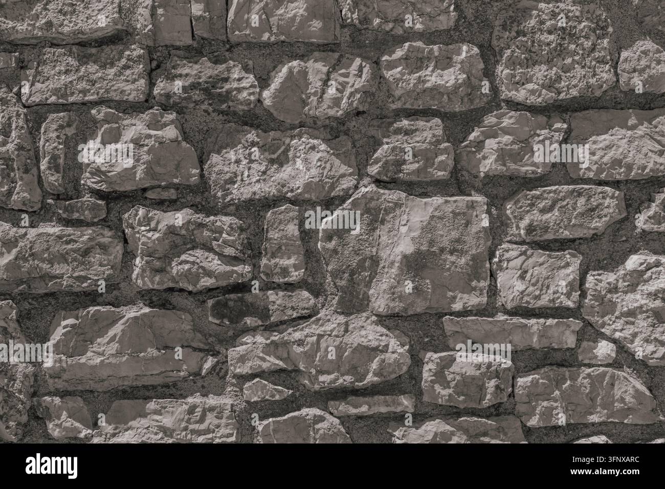 Texture di sfondo dettagliata di un vecchio muro di pietra grigia costruito con blocchi di calcare naturale grezzo per modelli architettonici, storici o all'aperto. Foto Stock