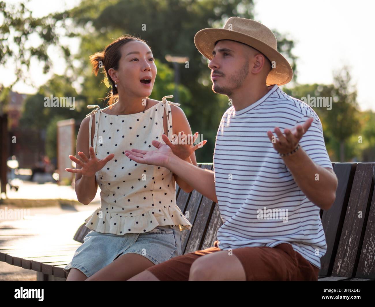 Uomo e donna che discutono di problemi di relazione con gesti espressivi all'aperto. Foto Stock