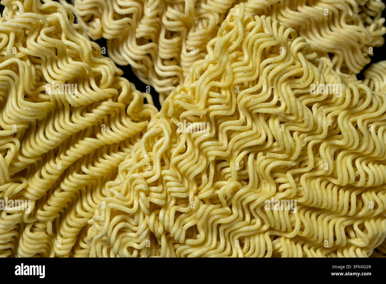 Blocchi di spaghetti istantanei Ramen crudi con motivo ruvido in primo piano Foto Stock