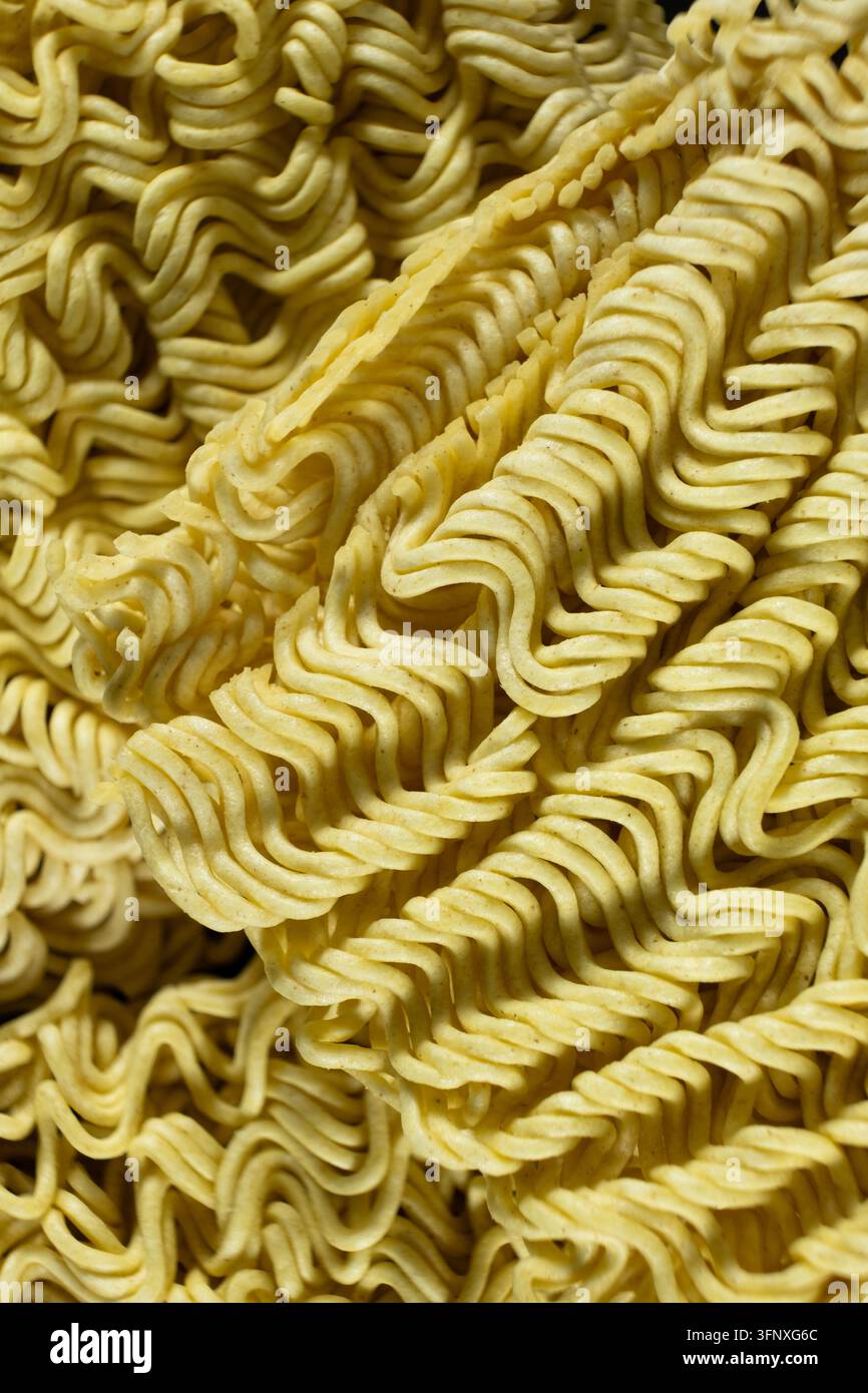 Texture dettagliata di un blocco di noodle istantanei Ramen ondulati crudi Foto Stock