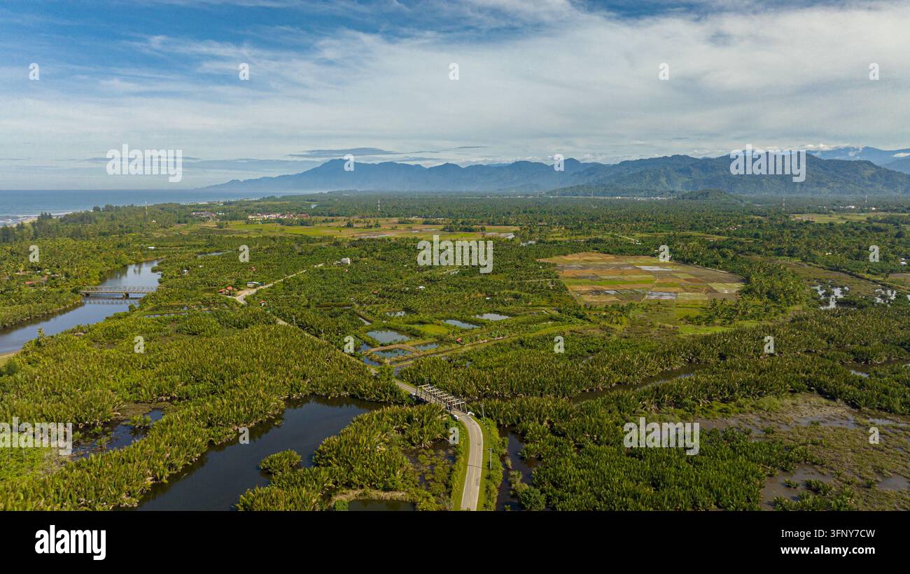 Vista aerea di terreni agricoli e montagne con cielo blu. Sumatra. Indonesia. Foto Stock