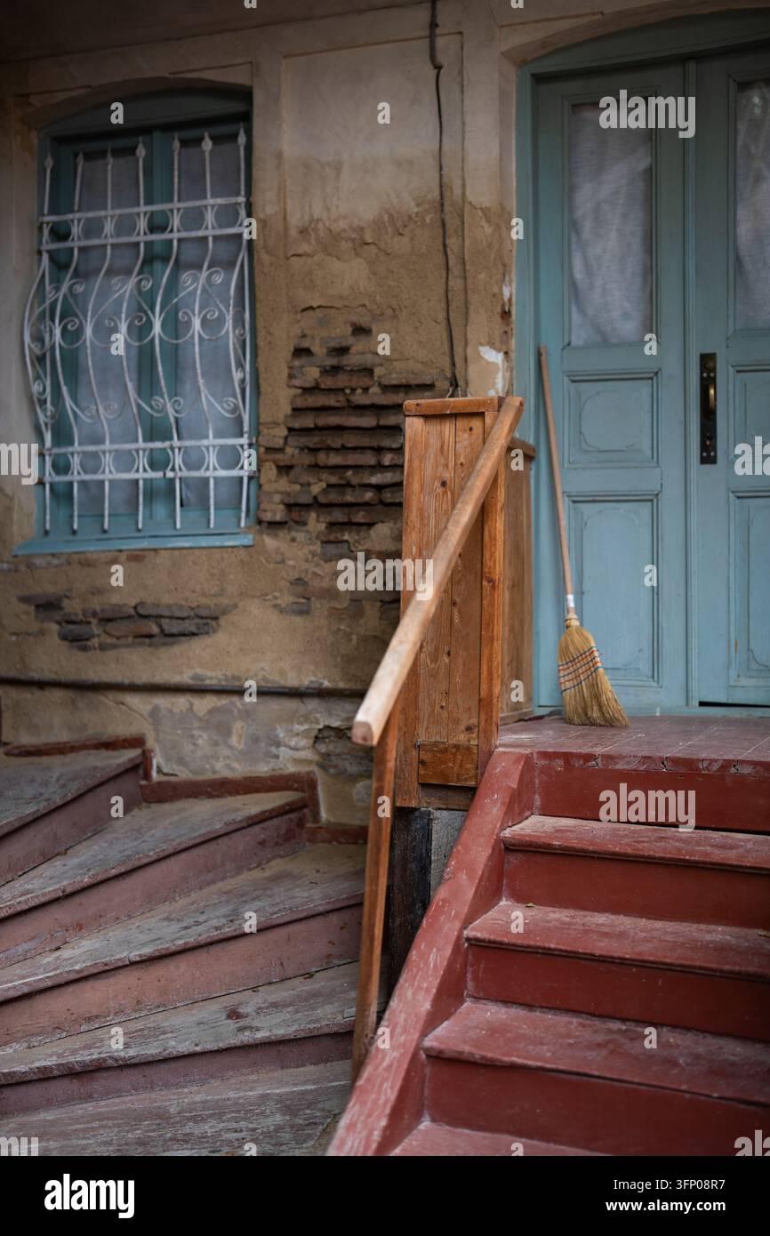 Parte di un edificio storico a Tbilisi, Georgia, con scale in legno vintage e porte d'ingresso. Foto Stock