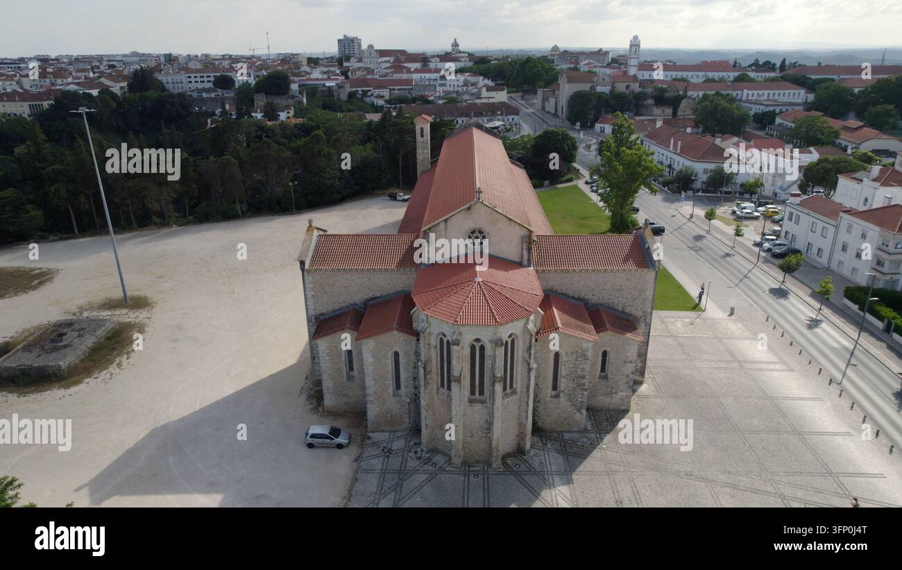 Vista aerea dell'Igreja de Santa Clara de Santarém, una chiesa storica in pietra con un tetto di tegole in terracotta, circondata dal paesaggio urbano di Santa Foto Stock
