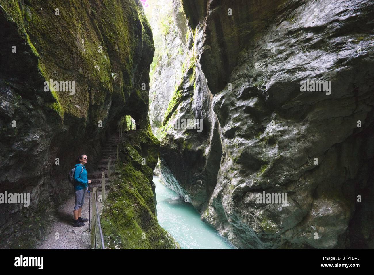 Un escursionista in piedi su un percorso pedonale all'interno della ripida gola di calcare delle Gole di Tolmin in Slovenia. Foto Stock