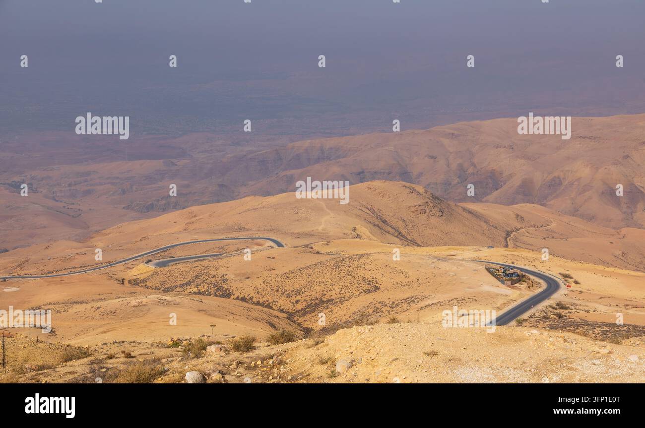 Vista aerea della strada tortuosa attraverso il paesaggio desertico arido vicino al Monte Nebo nel sottodistretto di Faisaliah, governatorato di Madaba, Giordania. Foto Stock