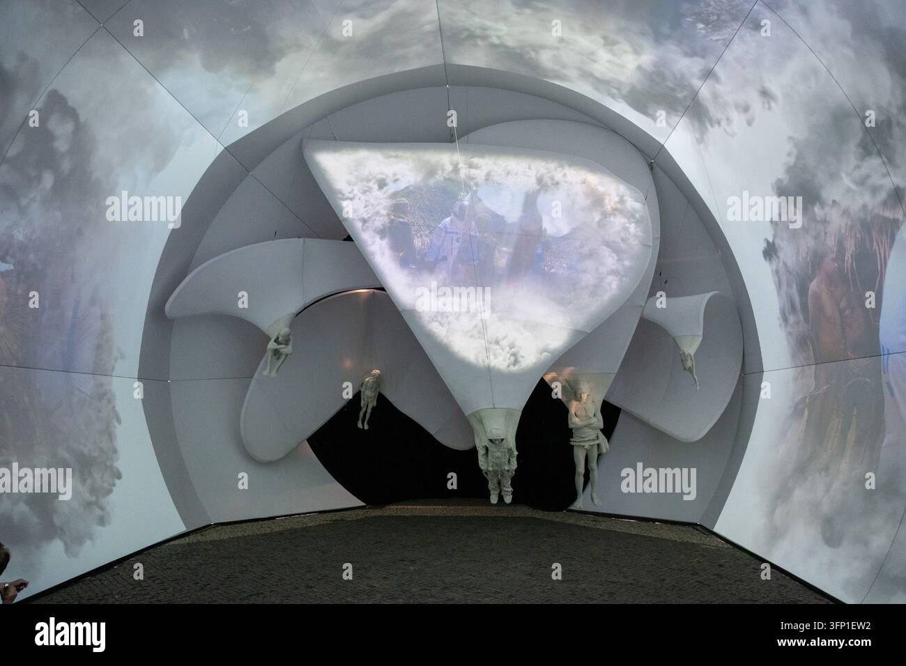 Un'installazione multimediale immersiva proietta immagini surreali di nuvole e figure umane sospese al Designblok 2026. Praga, Repubblica ceca, 5 ottobre Foto Stock
