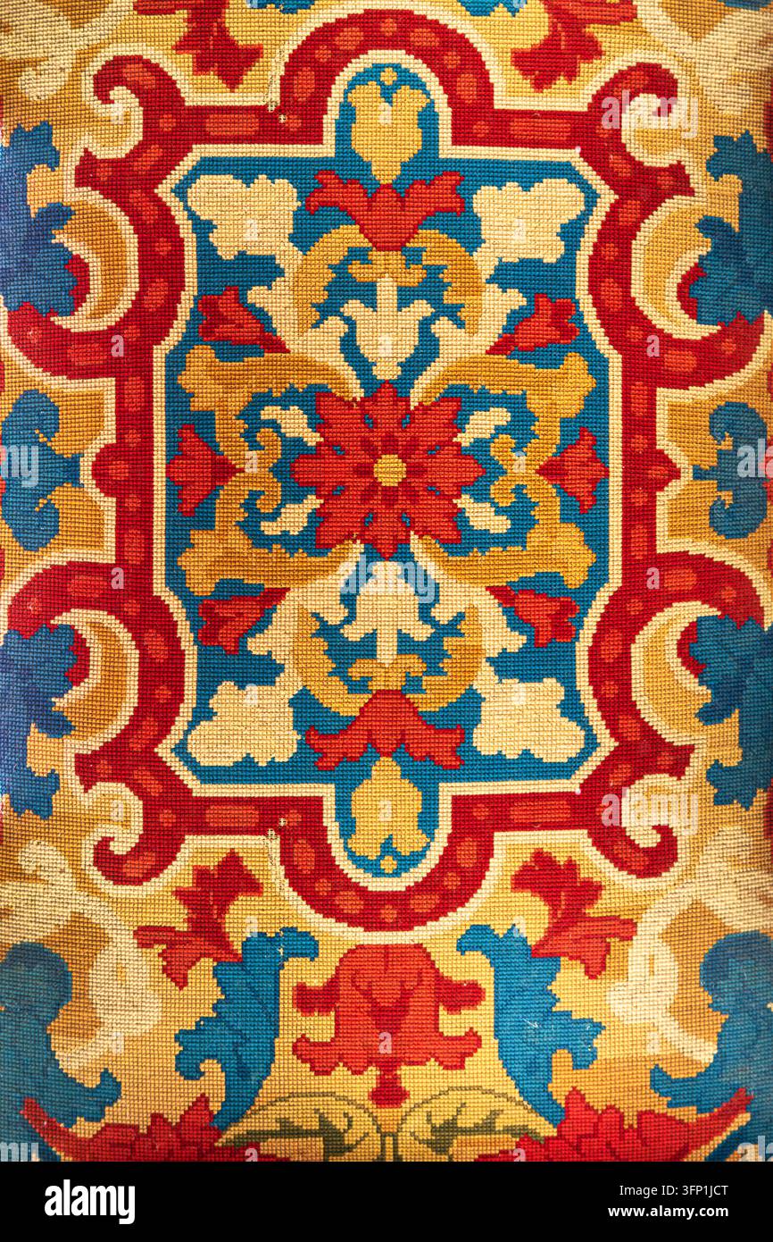 Prima di un tessuto ricamato antico che raffigura fiori colorati Foto Stock