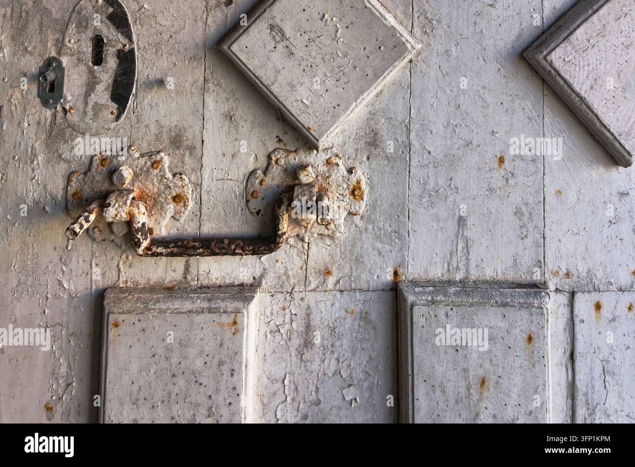 Dettaglio di una maniglia in metallo arrugginita su una porta molto vecchia dipinta di bianco, Museo dell'Abbazia di Mortemer Foto Stock