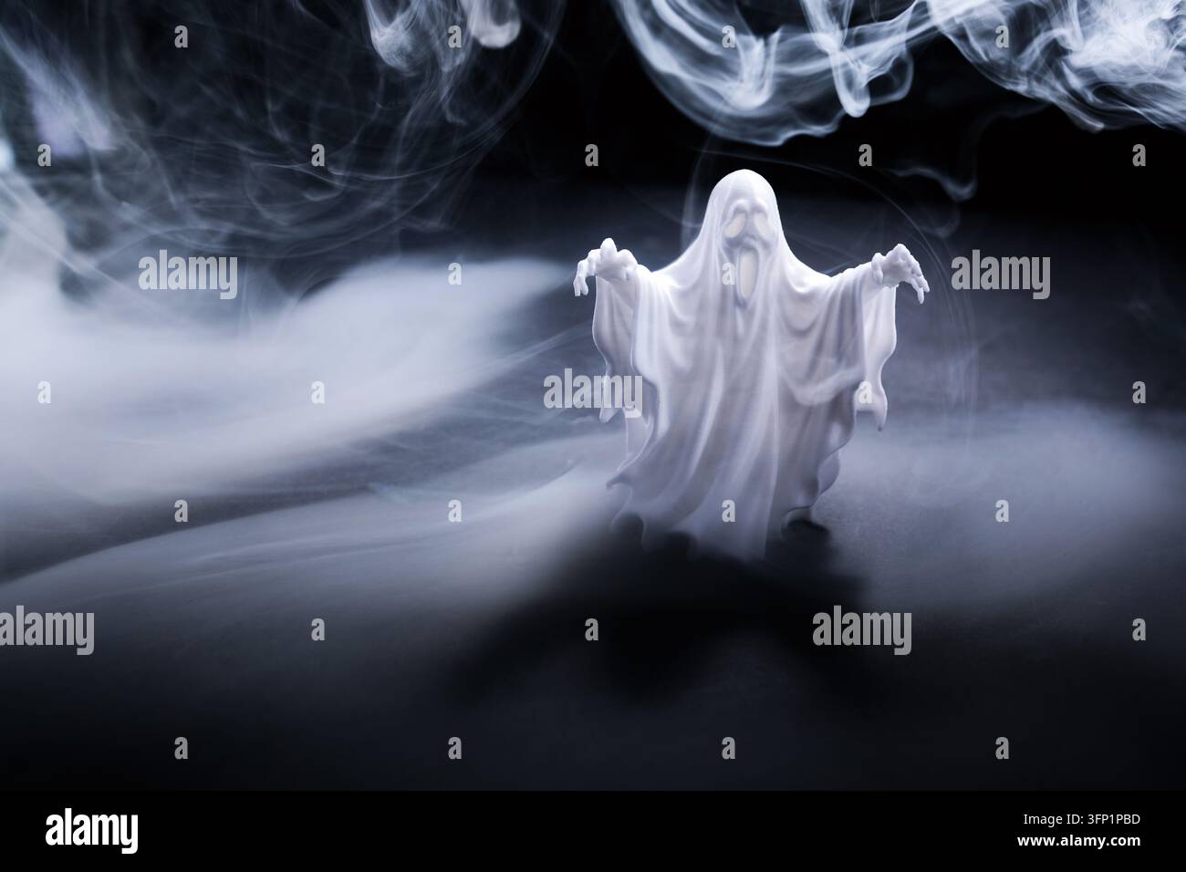 Figura fantasma bianca che emerge dal fumo scuro Foto Stock