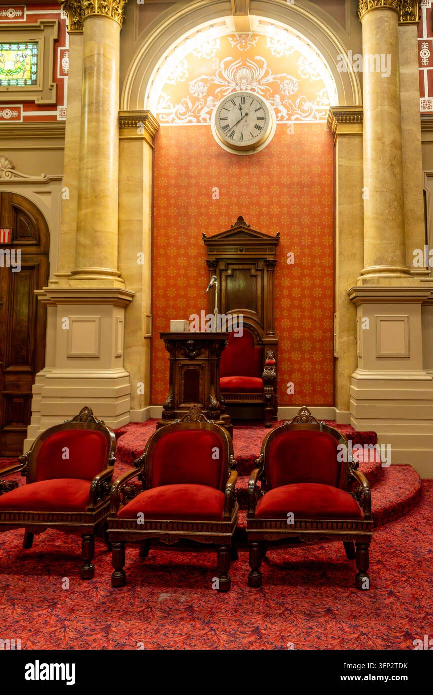 Filadelfia, Stati Uniti - 29 agosto 2026: Vista verticale simmetrica di un palco rialzato per maestro, sedie intagliate, orologio con numeri romani e colonna in marmo Foto Stock