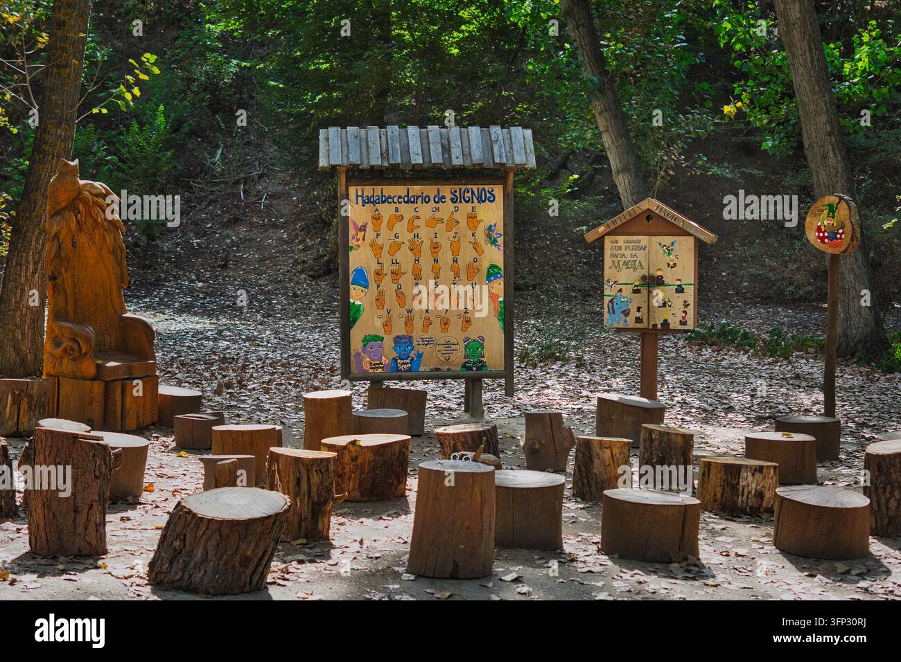 Tavole di legno illustrate e sedili in tronchi formano un'area di apprendimento all'aperto lungo il sentiero Senda Mágica ad Arroyomolinos, Madrid, Spagna. Foto Stock
