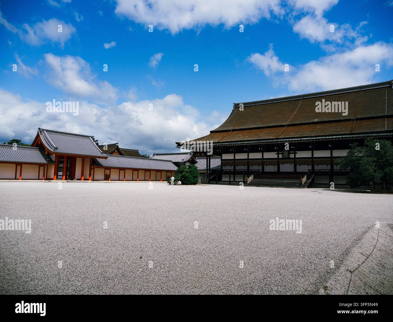 Sala Shishinden e cancello accanto al cortile di ghiaia bianca del Palazzo Imperiale di Kyoto sotto un cielo blu con nuvole, Kyoto, Giappone Foto Stock