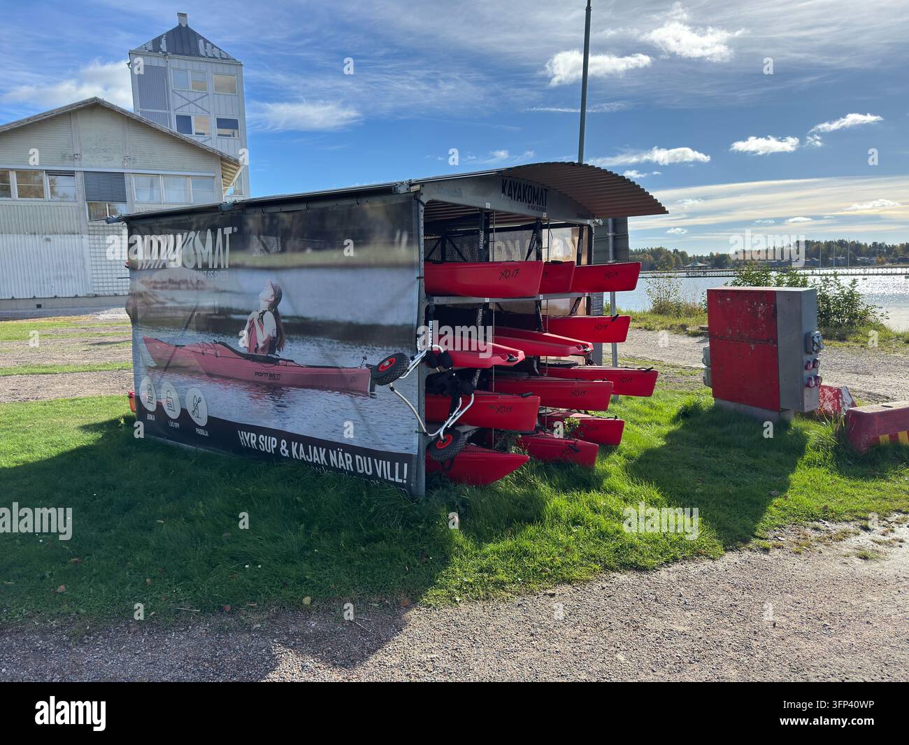 Nyköping, Svezia – 4 ottobre 2026: Kayakomat con kayak di noleggio rossi situati in riva all'acqua a Nyköping, Svezia. - Immagine stock catturata con smartphone