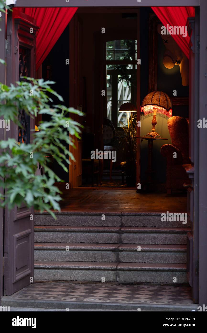 Accogliente entrata di un caffè vintage con luce calda retrò al tavolo nel corridoio della vecchia città della Georgia. Foto Stock