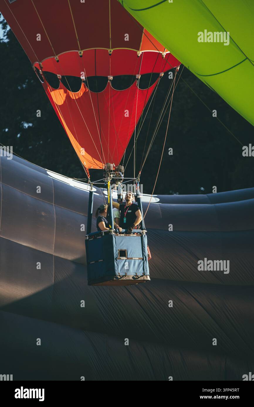 Festa dei palloncini di Bristol, 7 agosto 2026, Regno Unito – Cestini di mongolfiere con piloti che si preparano al volo all’interno delle pieghe dell’involucro Foto Stock