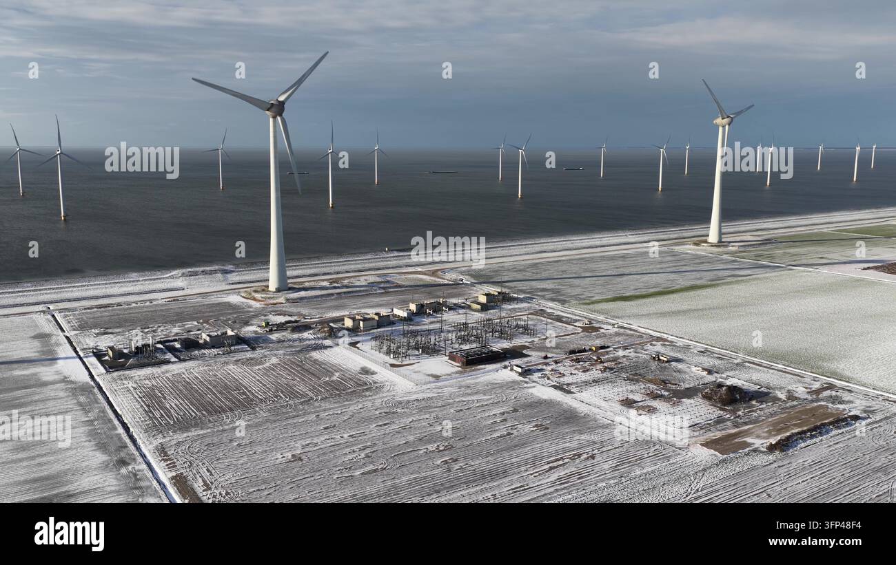 Parco eolico offshore che genera energia pulita in un paesaggio invernale Foto Stock