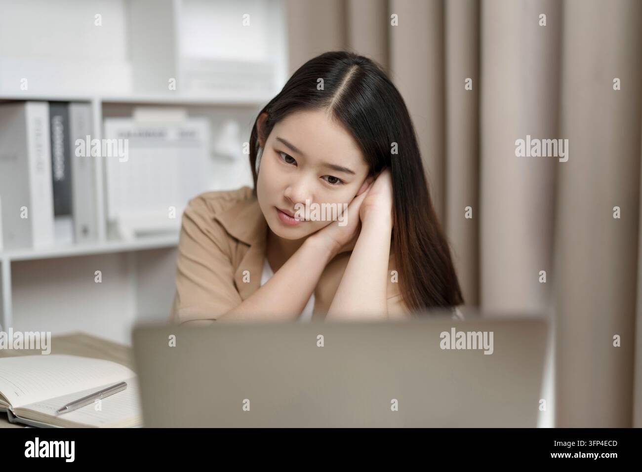 Giovane tutor online asiatica con laptop per videochiamata con i suoi studenti a casa Foto Stock
