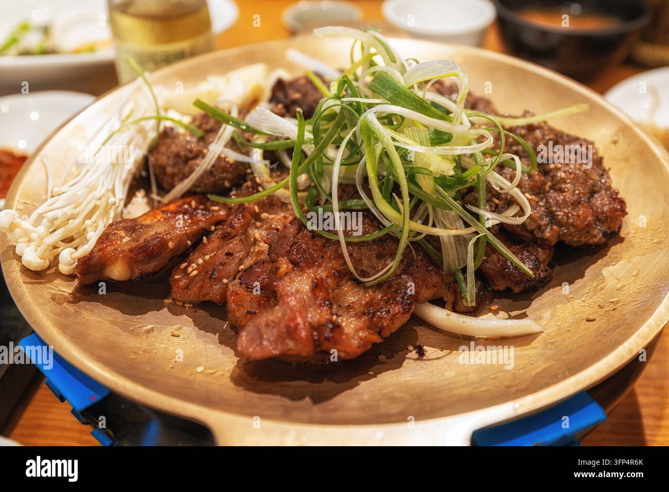 Tteokgalbi di Damyang servito su un piatto di bronzo con cipolle di primavera sopra. Cucina locale famosa a Damyang, Corea del Sud Foto Stock