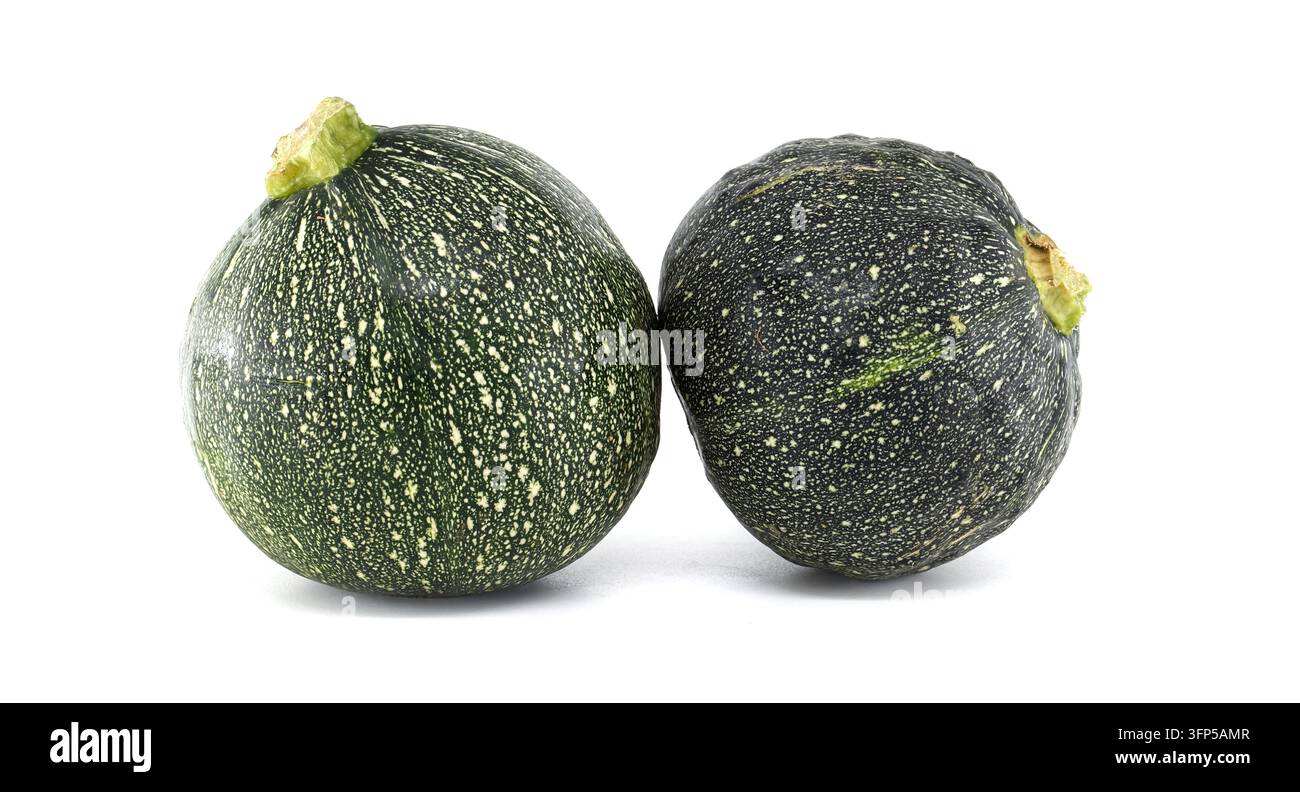 Un paio di zucchine fresche e rotonde con la caratteristica pelle verde macchiata sono presentate su uno sfondo bianco pulito Foto Stock