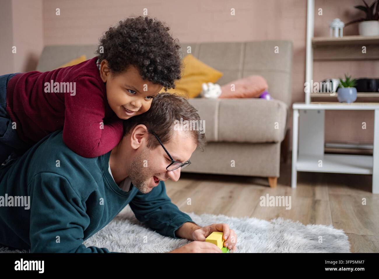 Padre e figlio giocano a casa, si legano e si divertono Foto Stock