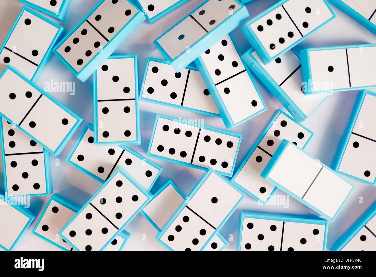 Sfondo a motivi di tessere di domino blu sparse – ideale per blog di strategia aziendale, marketing di giochi educativi, articoli di gestione del rischio e mentale Foto Stock