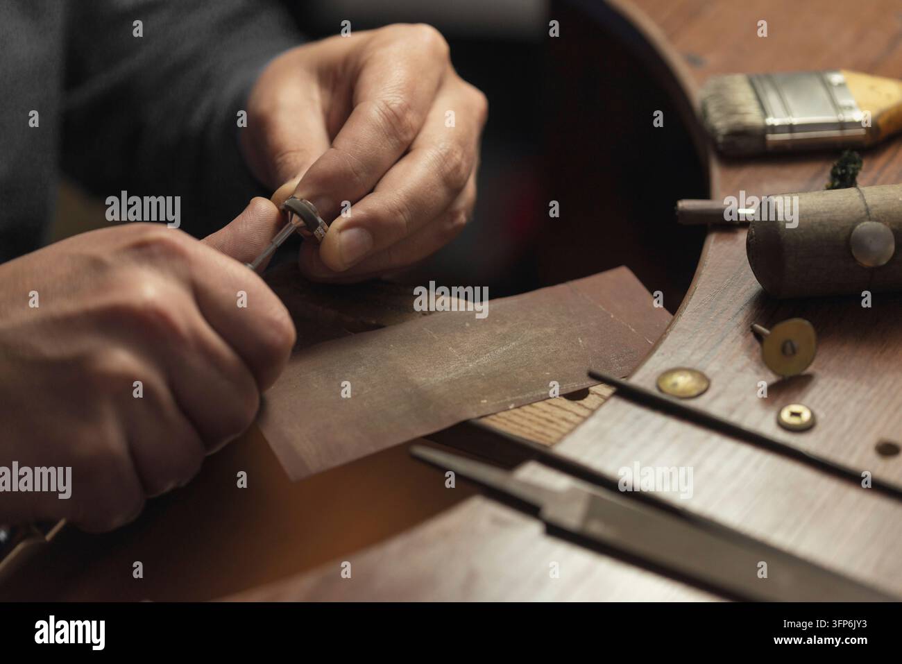 Tavolo da lavoro per la creazione di gioielli artigianali con strumenti professionali. Maestro di gioielleria lucidato manualmente anello d'oro con diamanti. Anello di matrimonio con diamanti su Foto Stock