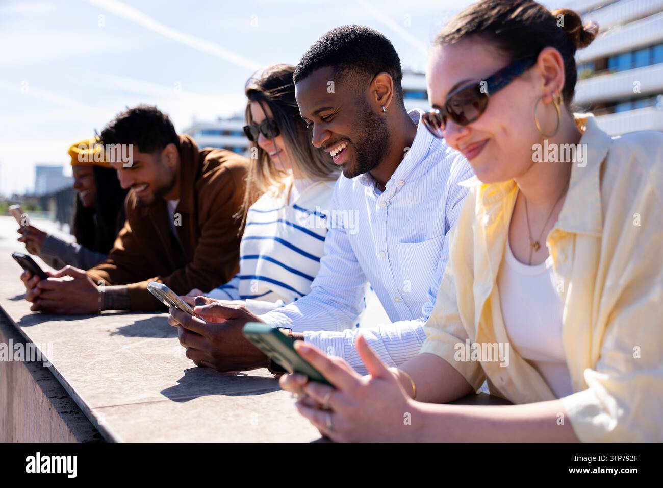 Amici diversi che utilizzano smartphone all'aperto e si godono la tecnologia Foto Stock