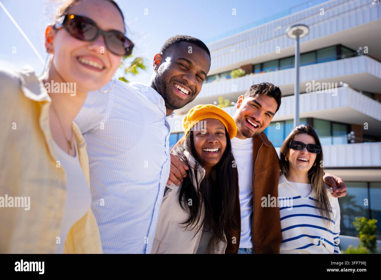 Amici diversi che sorridono, ridono, godono di una giornata vivace all'aperto Foto Stock